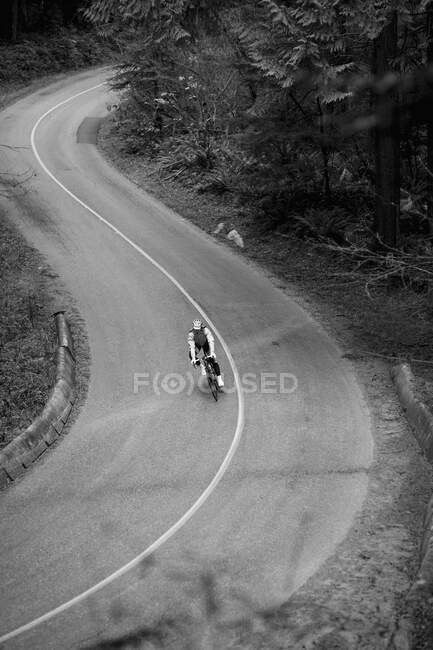 Vista de ángulo alto de ciclista montar en bicicleta en carretera del país - foto de stock