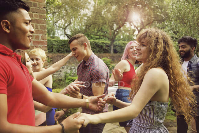 Веселые друзья танцуют во дворе во время вечеринки — стоковое фото