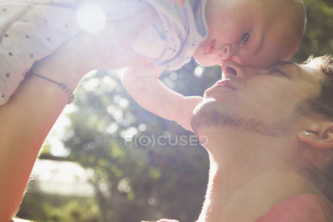 Padre cariñoso llevando al niño en un día soleado - foto de stock