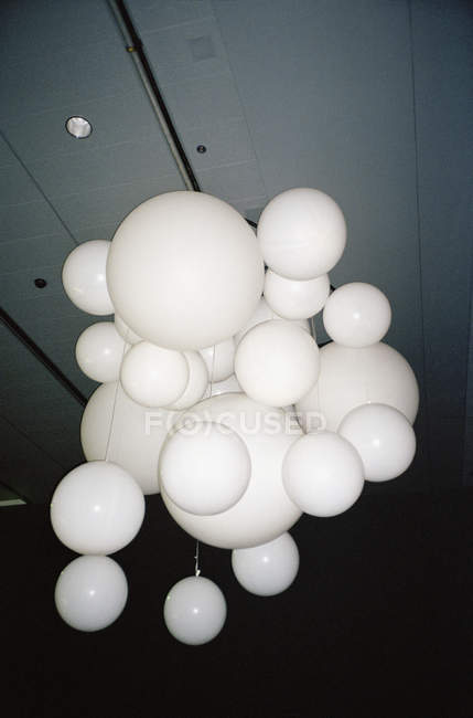 Вид снизу на связку белых шариков, свисающих с потолка — стоковое фото