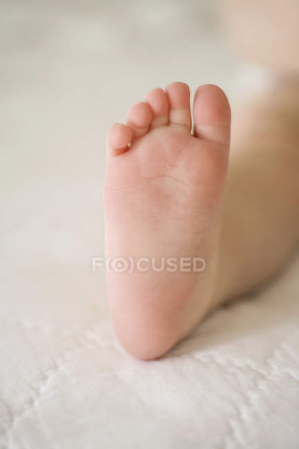 Vista de cerca del pie del bebé en la manta - foto de stock