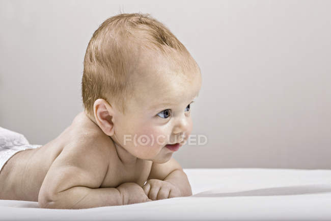 Estudio de tiro de bebé acostado en la cama - foto de stock