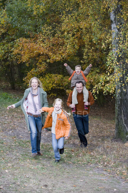 Family in park together in autumn — Stock Photo