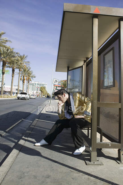 Имитатор Элвиса позирует на автобусной остановке — стоковое фото
