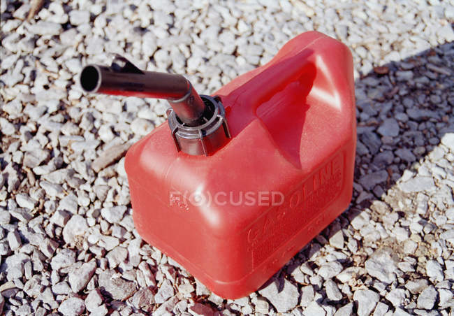 Latas de gas plástico rojo en guijarros - foto de stock