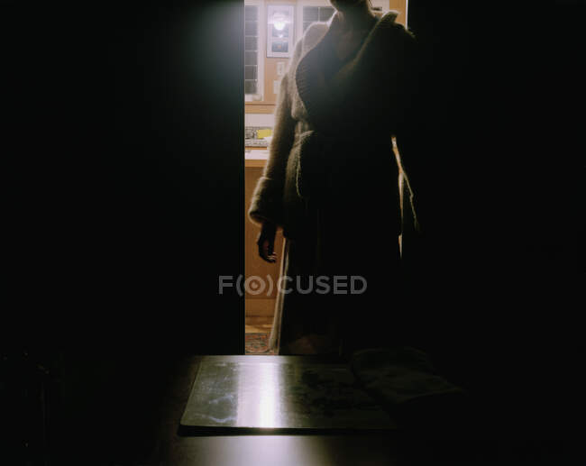 Donna in piedi sulla porta buia — Foto stock