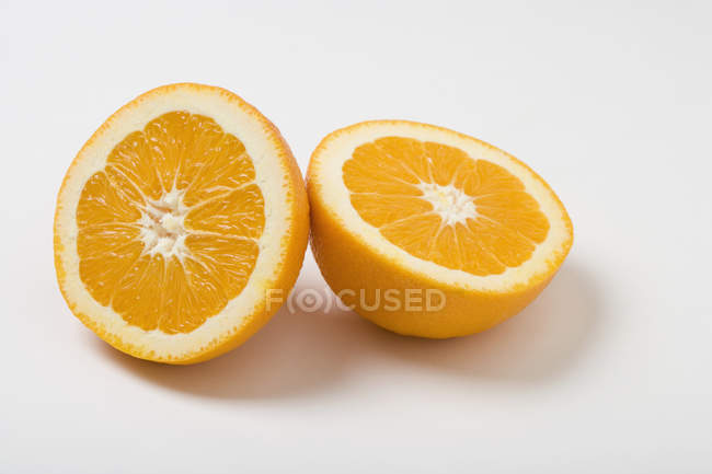 Vista de cerca de dos mitades naranjas sobre fondo blanco - foto de stock