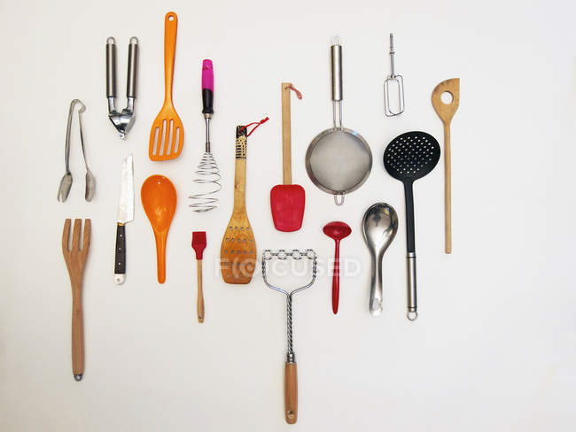 Kitchen utensils hanging on white wall — Stock Photo