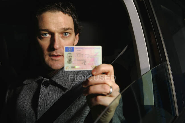Conductor masculino sosteniendo su tarjeta de identificación — Stock Photo