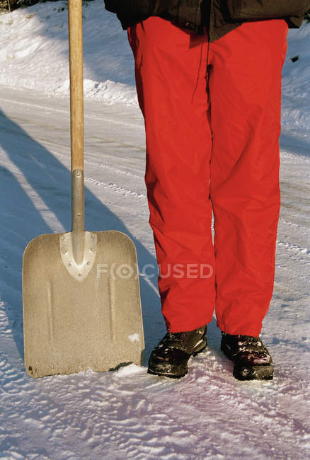 Low section of man standing next to shovel in snowac — Stock Photo