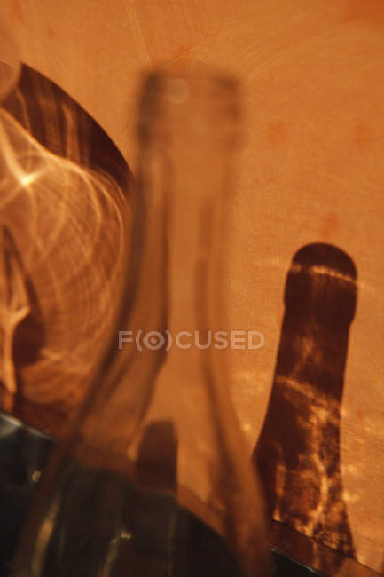 Refracción de luz y sombra de botella de vidrio haciendo patrón abstracto en la pared - foto de stock