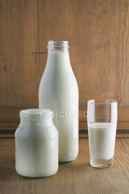 Vasetto di yogurt e bottiglia di latte in tavola — Foto stock