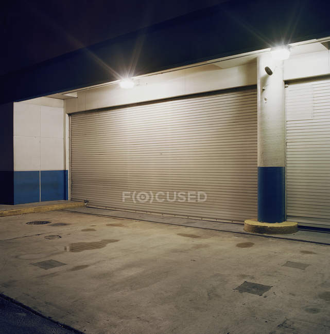 Floodlights Above Rolling Garage Doors At Loading Dock