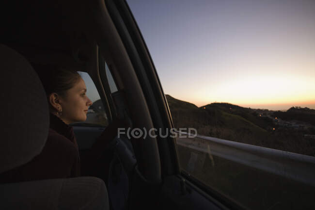 Mujer joven mirando por la ventana del coche - foto de stock