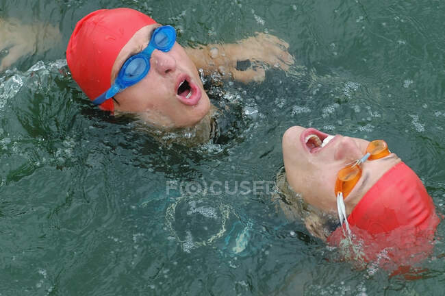Due nuotatori esausti in un lago con la testa sopra l'acqua — Foto stock