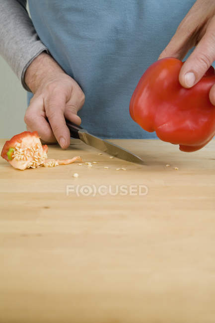 Crop male hands removing seeds from red bell pepper — Stock Photo
