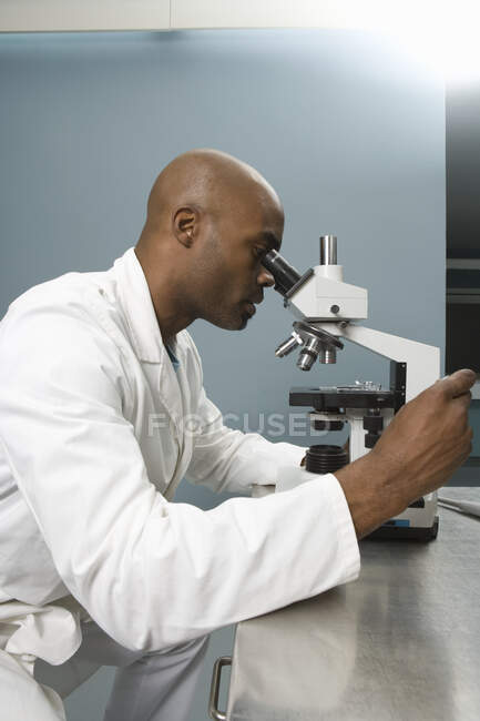 Tecnico che indaga sul microscopio — Foto stock