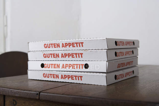 Stacked pizza boxes on table — Stock Photo