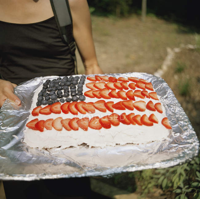 Woman carrying cake with usa flag made of berries — Stock Photo