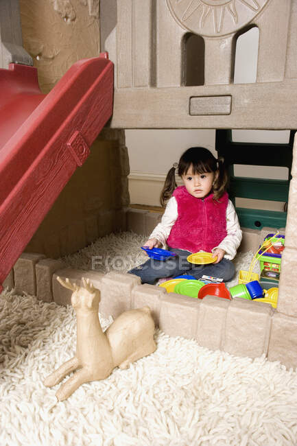 Une petite fille jouant avec des jouets — Photo de stock