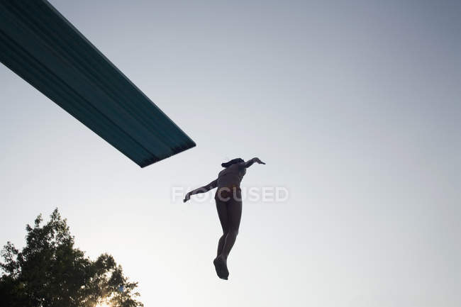 Silhouette di ragazza che salta dal trampolino a mezz'aria — Foto stock