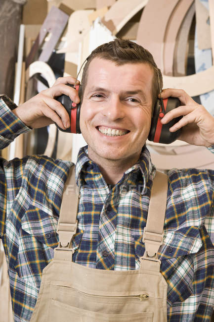 Retrato de carpintero feliz con protectores de oídos - foto de stock