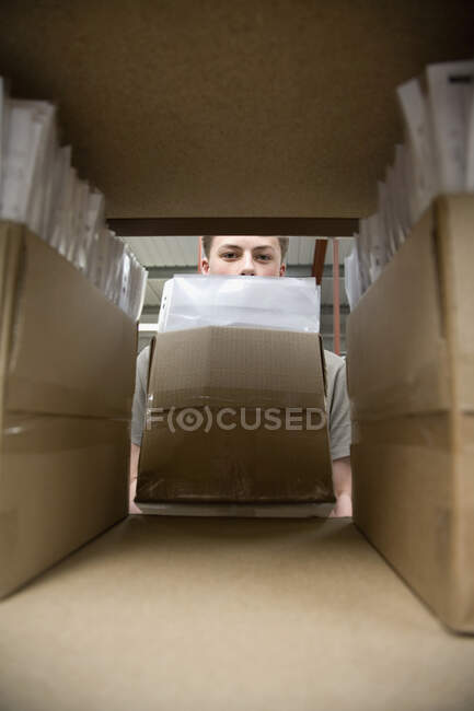 Un joven que guarda una caja de papeleo - foto de stock
