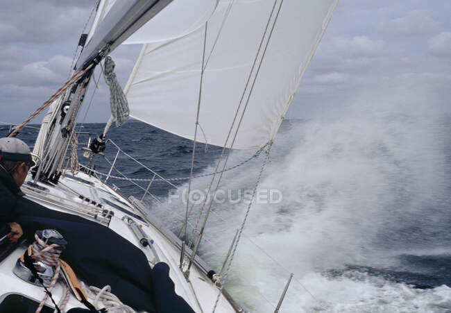 A man steering a yacht in rought weather — Stock Photo