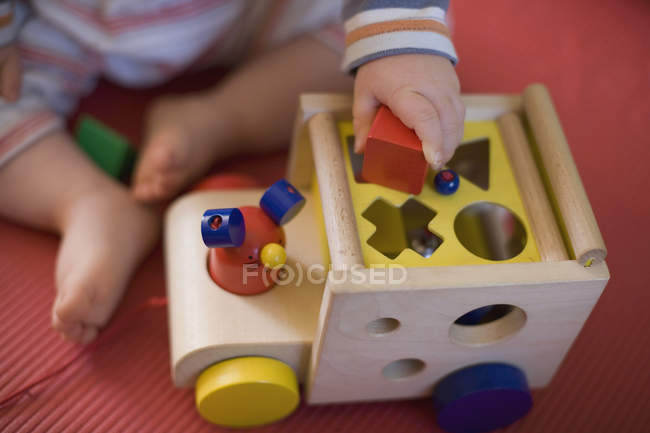Un bebé jugando con juguetes - foto de stock