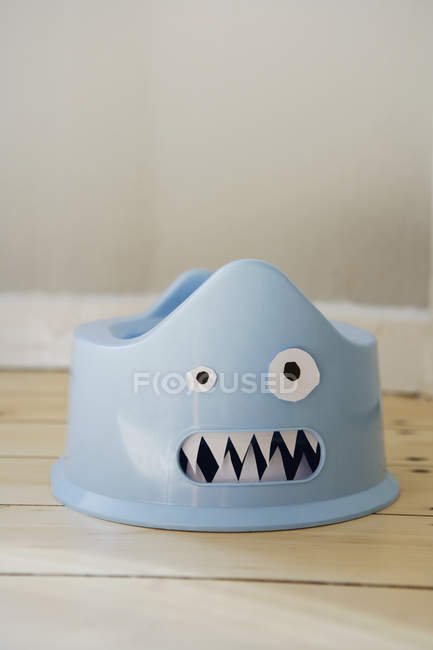 Plastic potty with cardboard face on floor — Stock Photo
