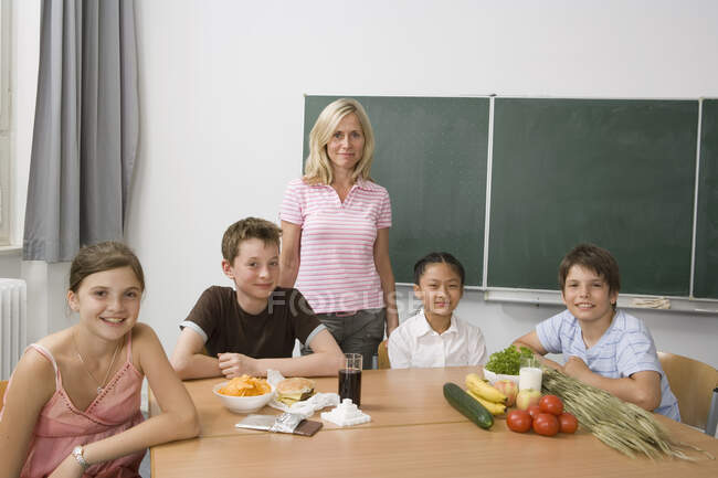 Un profesor y cuatro estudiantes aprendiendo sobre nutrición - foto de stock