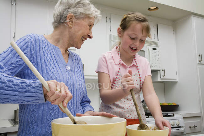 A grandmother and granddaughter preparing cookie dough — Stock Photo