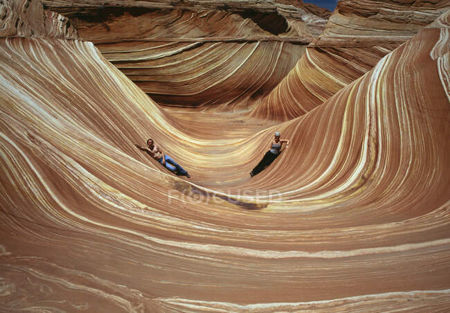Due persone si trovano a The Wave, Coyote Buttes, Paria Canyon-Vermilion Cliffs Wilderness, Arizona, USA — Foto stock