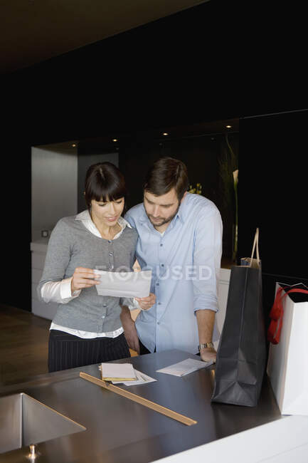 Un hombre y una mujer leyendo una carta - foto de stock