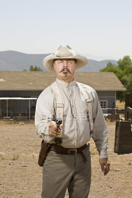 Portrait of a cowboy aiming his gun — Stock Photo