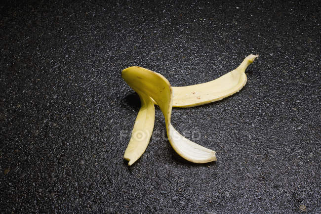 Отброшенная банановая кожура на поверхности асфальта — стоковое фото