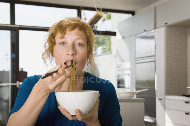 Una mujer comiendo salteados - foto de stock