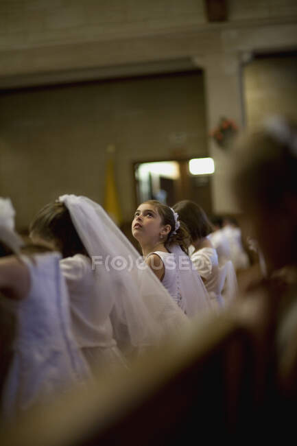 Молода дівчина дивиться на свою святу церемонію причастя. — стокове фото