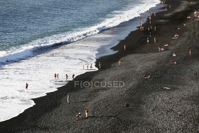 Vista ad alto angolo di persone che si rilassano sulla spiaggia di ghiaia — Foto stock