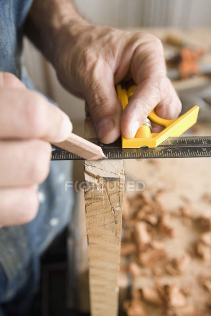 Crop carpenter's hands measuring plank — Stock Photo