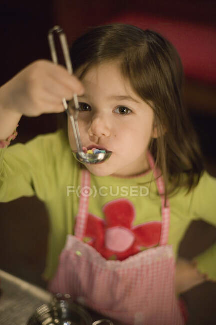 Young girl playing with a toy soup ladle — Stock Photo