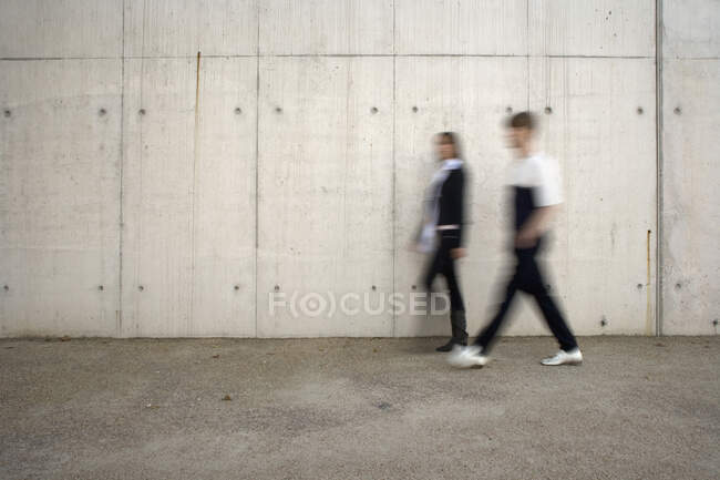 Два человека проходят мимо стены. — стоковое фото
