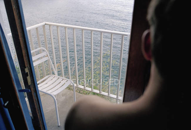 Переглянути через плече людини, дивлячись на море з балкони, Дорвей — стокове фото