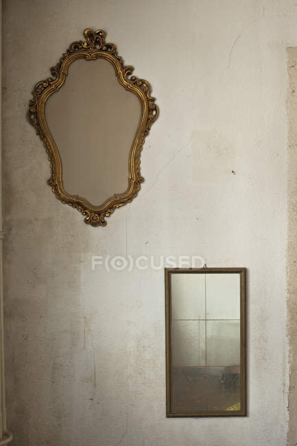 Dos espejos retro colgando de la pared desnuda - foto de stock