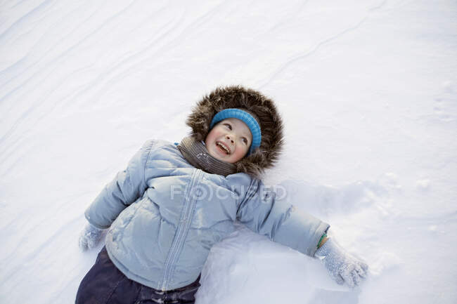 Um menino brincando na neve — Fotografia de Stock