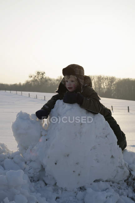Un enfant appuyé contre un tas de neige — Photo de stock