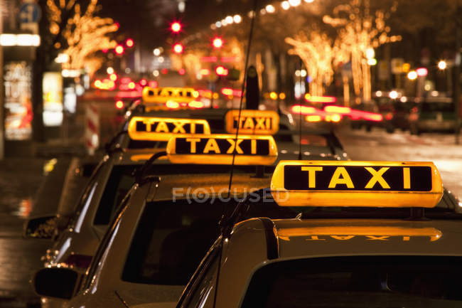 Crop taxi cabs parked in row at night street — Stock Photo