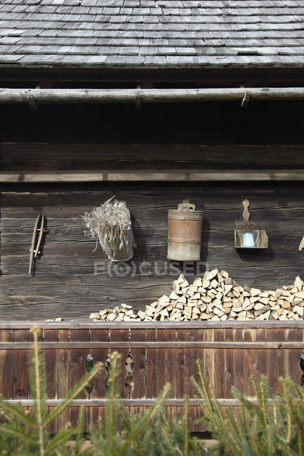 Barn Facade With Tools Hanging Over Stacked Logs Non Urban Scene