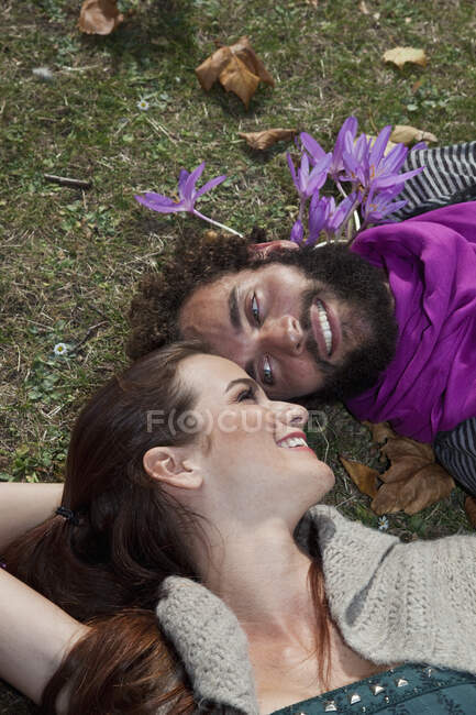 Una pareja yaciendo en la hierba - foto de stock