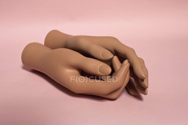Dos manos abrochadas maniquí en rosa - foto de stock